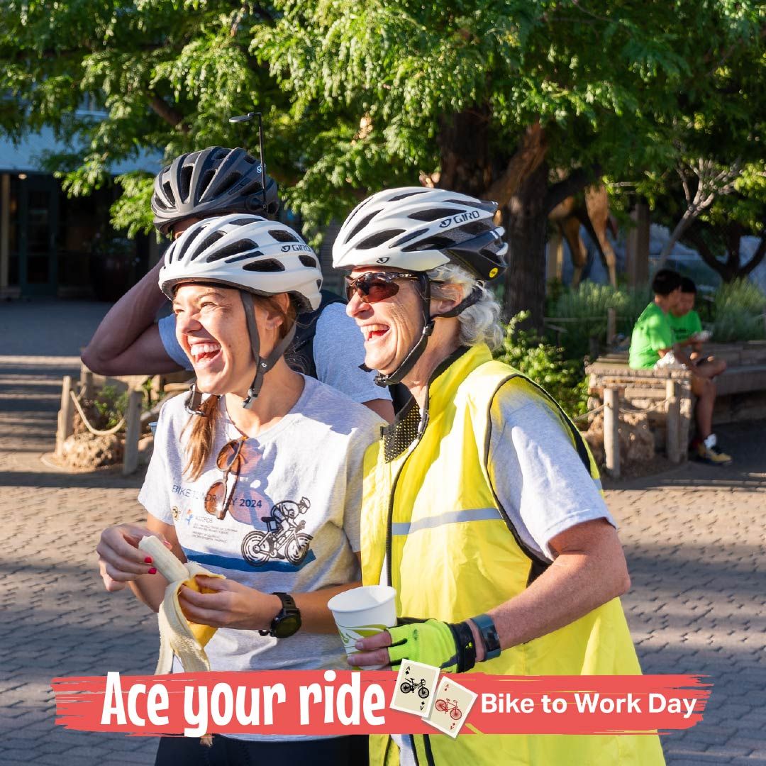 Two cyclists posing at a bike to work station with snacks and text that says ace your ride bike to work day